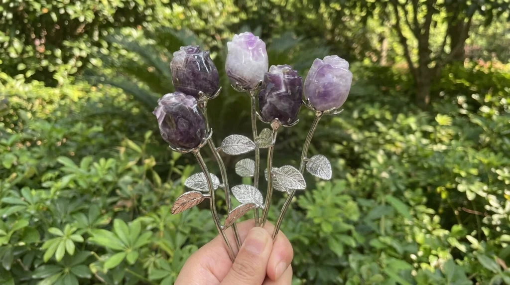 Hands supporting five purple and lavender crystal rosebuds on silver-colored stems and a small flared stand against a blurred green background
